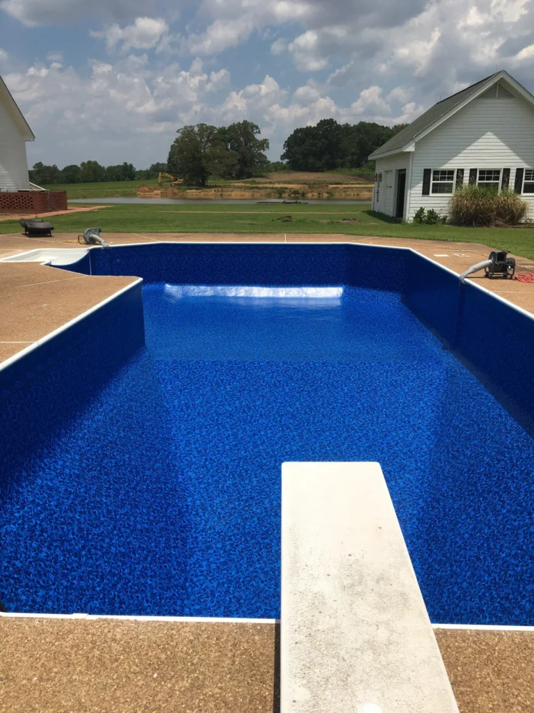 A blue swimming pool in a backyard.