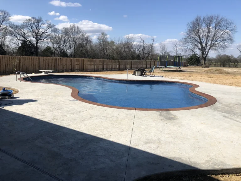 Freeform Mountain Blue pool in a fenced in backyard