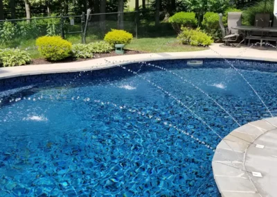 close view of a butterfly effect pattern pool with steps and basketball goal