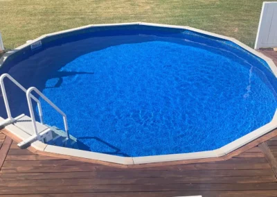 Reef River pattern Above-ground pool with a wooden deck around it